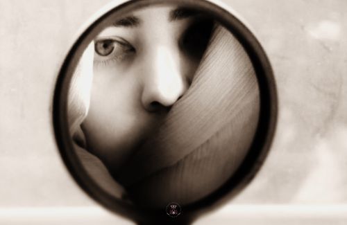 A mirror reflecting an image of an anxious person.