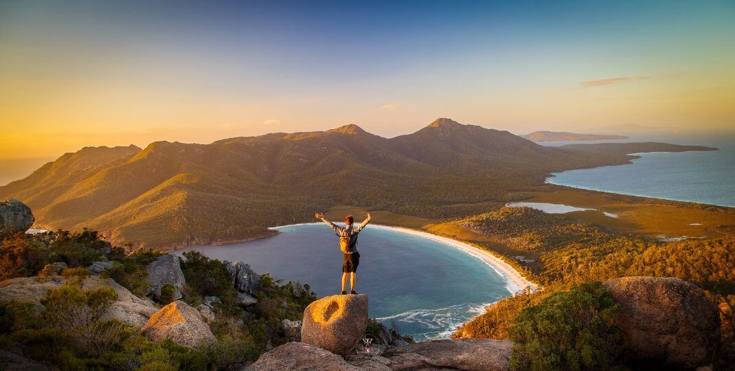 A person standing on top of a mountain, signifying the triumph over victimhood