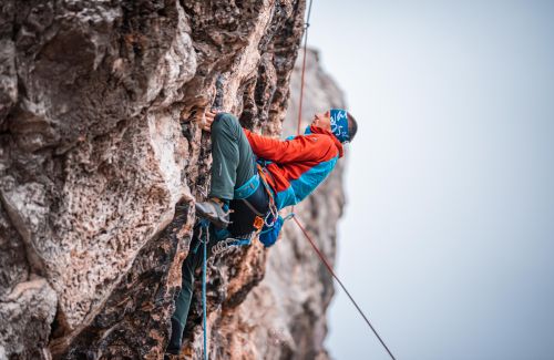 Person climbing a mountain, representing courage and overcoming challenges.