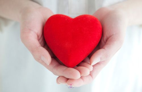 A pair of hands cradling a heart, depicting self-care and nurturing the inner child.