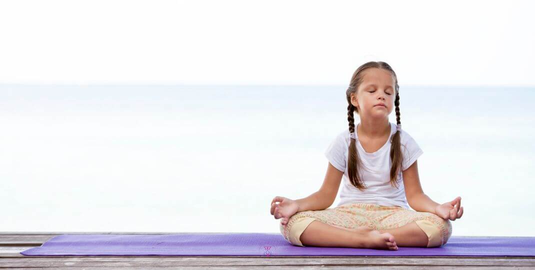 A serene landscape with a child sitting in meditation, illustrating the process of connecting with the inner child.