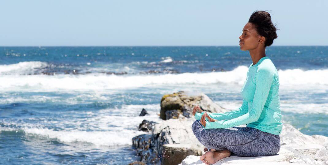 A serene landscape with a figure sitting in meditation, illustrating the process of connecting with the inner child.