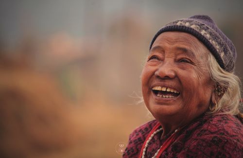 A close-up of a smiling face with natural wrinkles