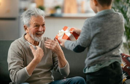 Picture of a smiling person receiving a surprise gift, illustrating the happiness and gratitude that accompany acts of giving.