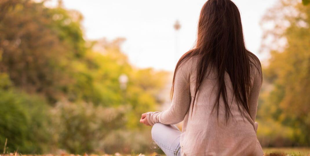 A person meditating peacefully in a serene natural setting