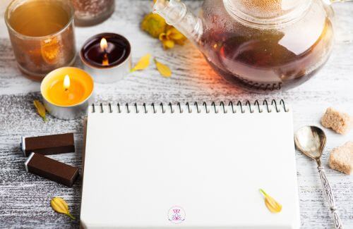 Finding balance in life - A peaceful desk scene with a notebook, a cup of tea, and a lit candle represents moments of slowing down and reflection.