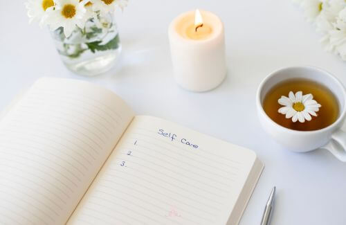 Take a Step Back - An open journal with a pen and a cup of tea beside it