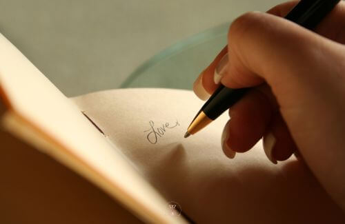 Finding Happiness Within - Soft Focus on Hands Holding a Journal, Open to Reflective Page