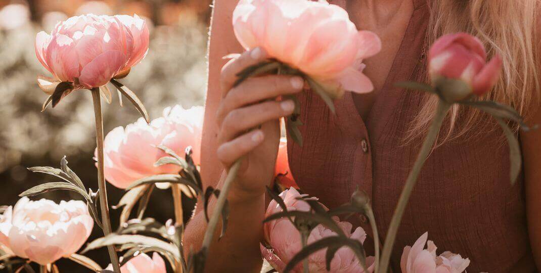 What You Focus on Becomes Reality - A close-up of hands gently holding a blooming flower against a serene background.